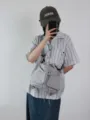 Dettaglio borsa a secchiello in nylon grigio con spallacci regolabili e chiusura a cordoncino. - Grigio