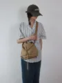 Vista dettagliata della borsa a secchiello casual in tessuto oxford cachi con coulisse e spallina. - Cachi