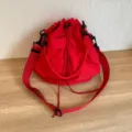 Borsa a secchiello con coulisse in tessuto oxford rosso e tracolla regolabile per uso quotidiano. - Rosso