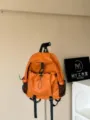 Vue détail du sac à dos étanche orange avec poches multiples et poches en maille pour voyage. - L / Orange