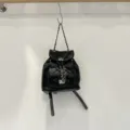 Black quilted leather backpack with metallic chain straps and secure flap turn lock design. - Black PU