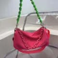 Trendy pink fabric shoulder bag with unique green knotted strap and stylish chain decoration. - Rose Red
