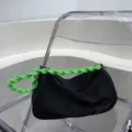 Stylish black canvas underarm shoulder bag with neon green woven strap for daily commute. - Black