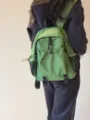 Vue rapprochée du sac à dos en nylon vert décontracté avec plusieurs poches et filets. - S / Vert