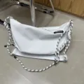White oxford cloth dumpling crossbody bag with stylish black-white knotted rope straps. - White