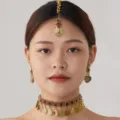 Close-up of a bohemian ethnic gold coin choker necklace and earrings set with red gems. - Red