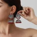 Detailed shot of ethnic bohemian silver filigree long tassel jhumka earrings with red beads. - Dark Red