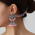 Close-up detail of vintage ethnic style silver jhumka earring with pink beads and chain. - Pink