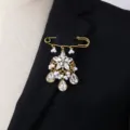 Vintage crystal pearl brooch pin, elegant gold tone safety pin jewelry for women detail shot - White