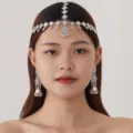 Close-up of vintage silver ethnic forehead chain and jhumka earrings set with pink rhinestones. - Pink