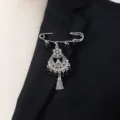 Detail view of vintage silver-tone metal rhinestone tassel brooch pin on black suit lapel. - Black