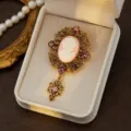 Vintage cameo brooch with ornate filigree metal frame, sparkling rhinestones and pendant charm. - Style 3