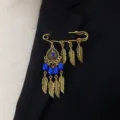Vintage bohemian style golden safety pin brooch with blue beads and feather charms. - Blue
