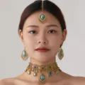 Vue détaillée de l'ensemble de collier ras du cou vintage doré ethnique et de boucles d'oreilles. - Vert