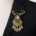 Vintage bohemian style gold coin tassel brooch pin detail shot showcasing intricate design. - Purple