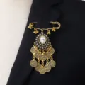 Vintage gold tone coin tassel brooch detail, ornate rhinestone oval pendant pin accessory. - White