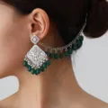 Close-up detail of ethnic vintage silver carved hollow earring with green beads and chain. - Silver Green