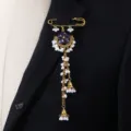 Close-up of vintage ethnic rhinestone brooch with delicate white pearl long tassels and gold pin. - Purple