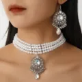 Detail view of the vintage multi-strand faux pearl choker necklace and rhinestone earrings. - White