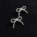 Close-up display of sparkling rhinestone bow tassel earrings, showing delicate crystal craftsmanship. - Style 3
