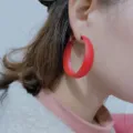 Matte red hoop earrings detail close-up showing smooth finish and stylish geometric design. - Red