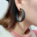 Matte black geometric hoop earrings detail view, showcasing minimalist design and elegant style. - Black