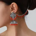 Detailansicht vintage ethnischer indischer Jhumka-Ohrringe mit roten Perlen Haarkette. - Orangerot