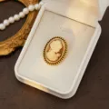 Vintage cameo brooch featuring an elegant lady portrait with a sophisticated gold beaded border. - Style 7 (Gold Edge Relief)
