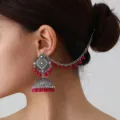 Nahaufnahme der böhmischen indischen gravierten Silberjhumka-Ohrringe mit rosa Perlen. - Fuchsia