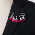 Close-up of bohemian silver-tone bell tassel brooch with hot pink beads on suit lapel. - Rose Red