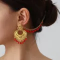 Detail shot of vintage Indian style gold-plated ear chain with red bead fringe, ethnic. - Gold Red