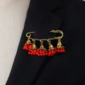 Vintage gold tone jhumka tassel brooch pin with red beads for elegant women fashion detail. - Red