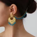Close-up detail of ethnic gold-plated filigree ear chain with turquoise beads, vintage design. - Gold Blue