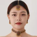 Exquisite vintage Indian jewelry set featuring intricate gold choker, earrings and maang tikka. - Gold Red