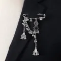 Close-up detail of vintage silver bohemian tassel safety pin brooch with bells and black stone. - Black