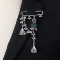 Close-up detail view of the vintage silver-tone bohemian tassel brooch pin accessory. - Green