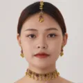 Detail shot of bohemian ethnic gold choker necklace, earrings and maang tikka jewelry set. - Gold Red