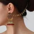 Detailaufnahme retro indischer Jhumka Ohrringe mit Haarkette und roten Perlen für Stil. - Rot