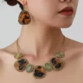 Detailed view of retro tortoise shell necklace and earrings set featuring textured gold finish. - Gold Amber