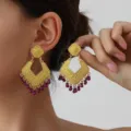 Vintage gold-tone statement earrings featuring intricate filigree rhombus designs and purple bead fringe. - Gold and Purple