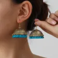Exquisite detail shot of vintage ethnic jhumka tassel earrings with turquoise beads. Close-up. - Gold and Blue