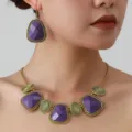 Vintage purple geometric necklace and earrings close-up showing gold metal retro style. - Gold and Purple