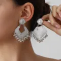 Detailed view of vintage silver geometric engraved drop earrings with delicate tassel beads. - Silver