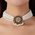 Close-up detail of multi-strand pearl choker necklace with vintage crystal floral pendant. - White