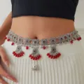 Nahaufnahme der böhmischen silbernen Taillenkette mit Vintage-Metallscheiben und roten Perlen. - Silberrot