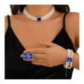 Detailed shot of retro pearl necklace bracelet and earrings set with blue crystal center. - Blue