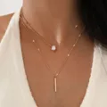 Gold layered necklace featuring teardrop zirconia and minimalist bar pendant design. - Tear-drop Rhinestone Double-layer Necklace / Gold
