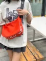 Casual canvas crossbody bag, orange crescent moon design with wide strap, detail view. - Red