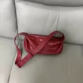Red leather pleated shoulder bag detail view showcasing soft texture and wide strap. - Red