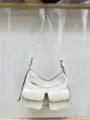 Detailed close-up of white motorcycle shoulder bag showing multiple exterior pockets and zippers. - White